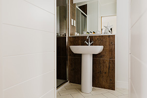 Magnificent white tiled bathroom with brown accents